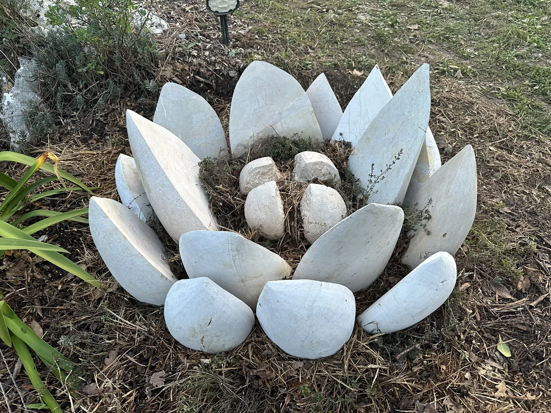 Vue générale d'un lotus sculpté dans la pierre et installé dans un jardin